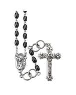 5 x 7mm Oval Black Glass Bead Rosary with Gold Tone Wedding Ring Our Father Beads.
Fine detailed gold tone centerpiece and crucifix.
20" (508mm) Rosary length.
Comes in a grey velvet box. Made in USA.